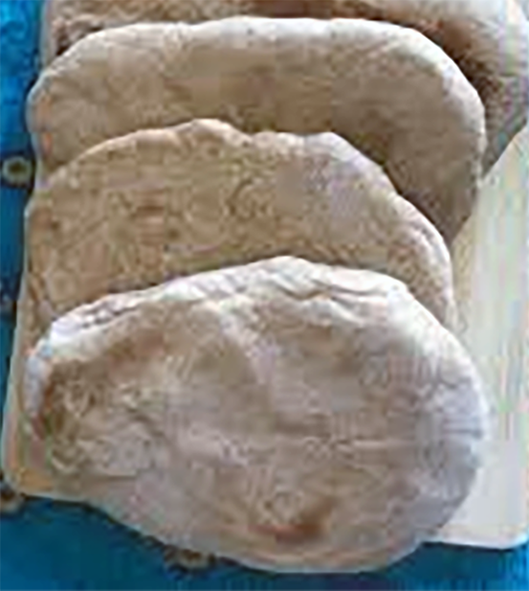 kibris pidesi turkish cypriot flatbreads stacked on a wooden cutting board