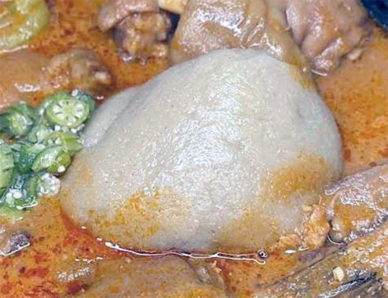 kokonte served in the centre of a chicken stew