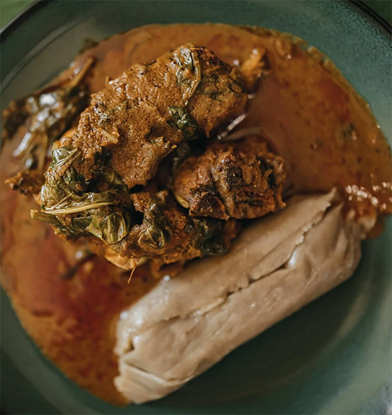 Banga soup served on a plate accompanied with steamed kwacoco