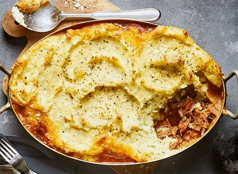 lamb shank pie with parsnip and breadcrumb topping in a steel baking dish