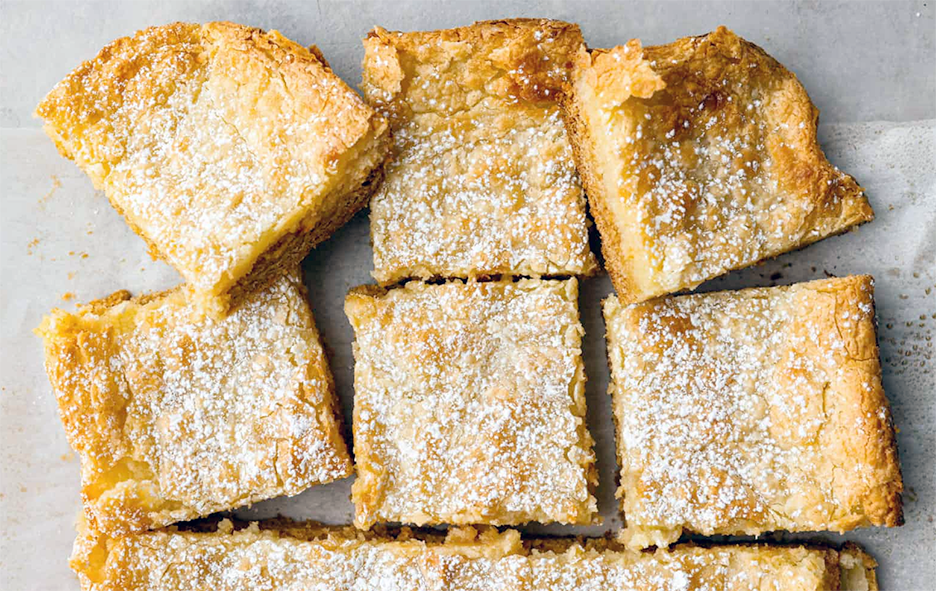 lard cree cake cut into squares and dusted with caster sugar
