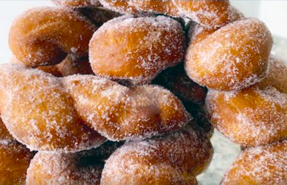 liberian twisted doughnuts sprinkled with sugar and piled on a plate