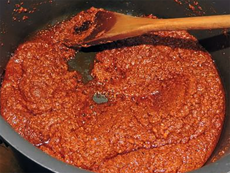 Madras curry paste cooking down in a saucepan