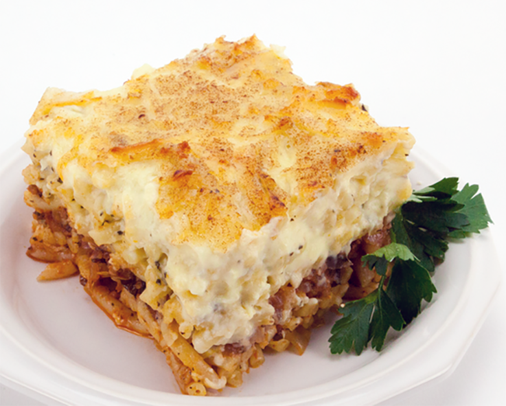 square of Cypriot macaroni and meat bake on a white plate with a sprig of parsley