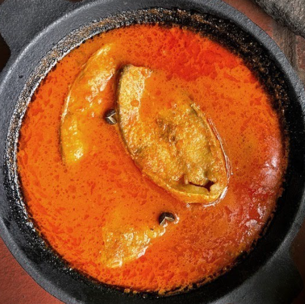 malvani fish curry served in a wrought iron dish