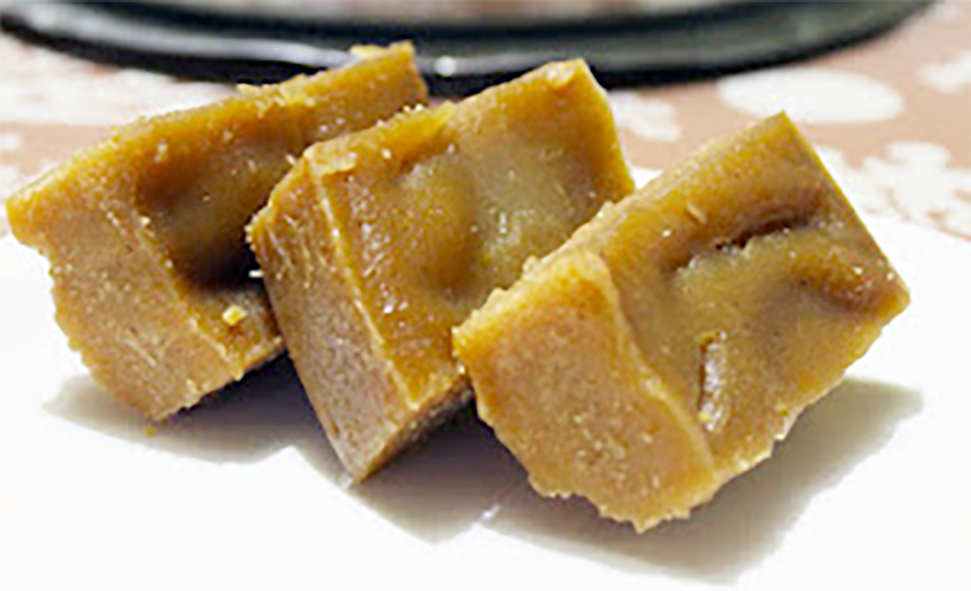 Three slices of red pumpkin mandas stacked up on a plate