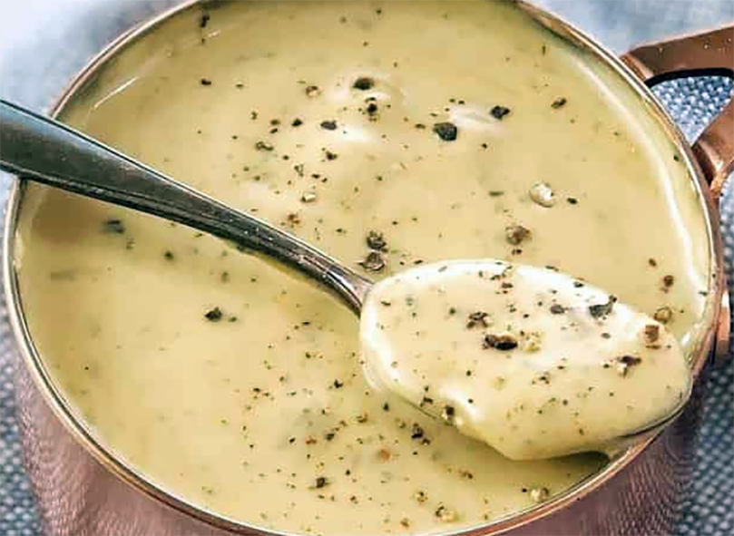 Michael Kelly's sauce in a copper pan topped with cracked black pepper