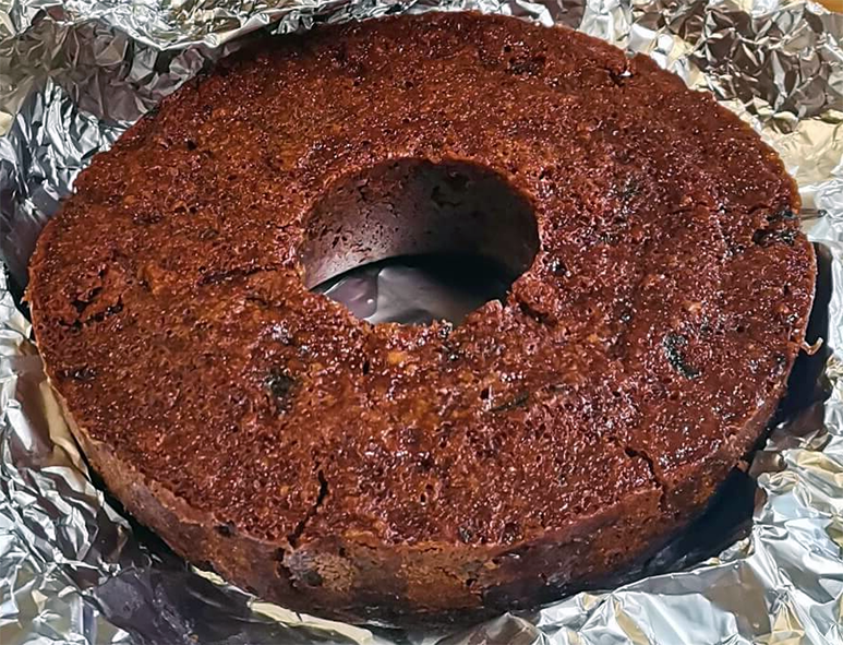 Microwaved Christmas ring cake turned out onto a sheet of kitchen foil