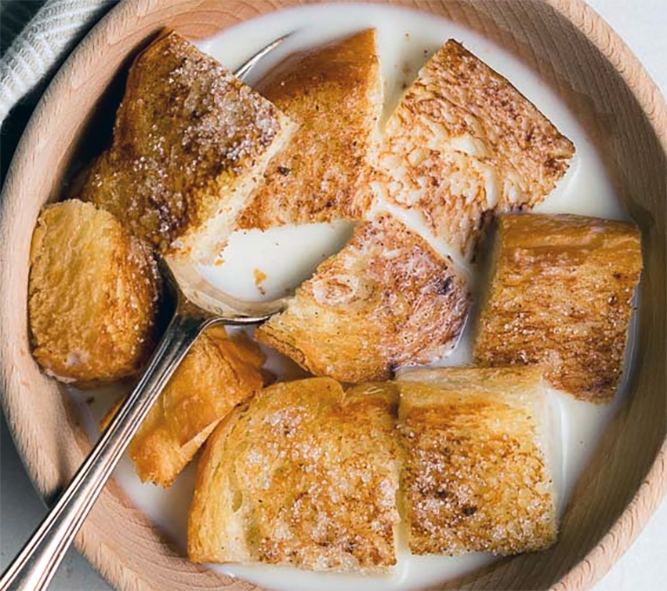 milk toast served in a wooden bowl with a spoon