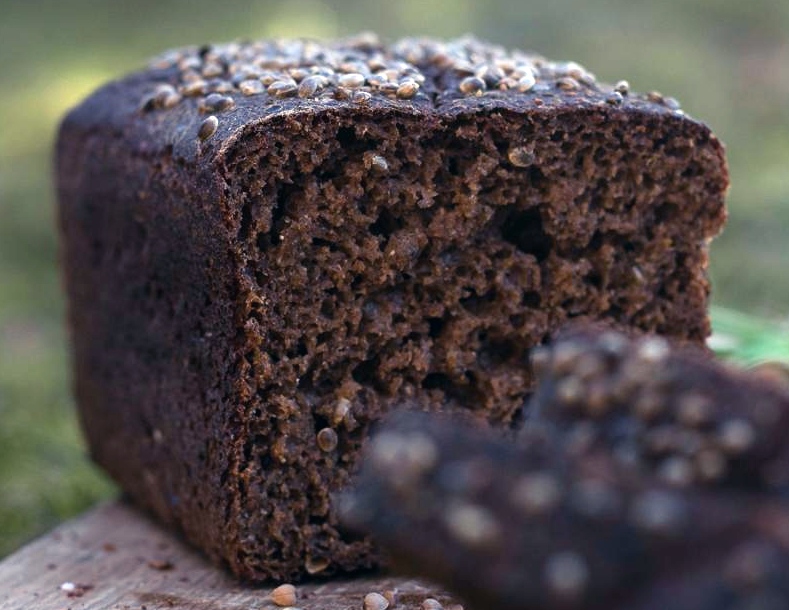 loaf of Estonian black bread with slices in front