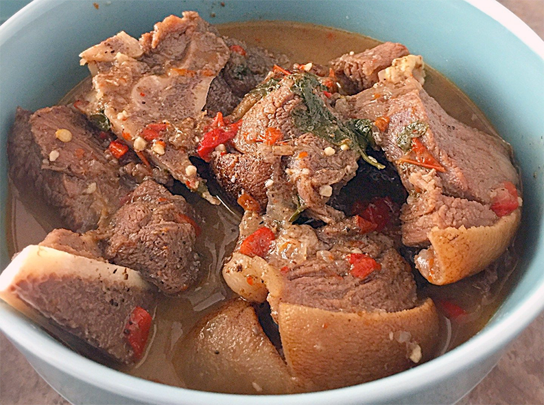 goat meat pepper soup served in a blue bowl