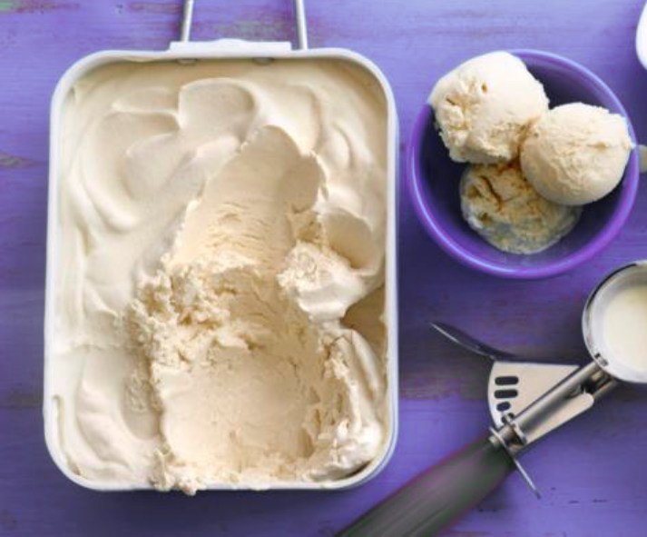 no-churn Irish cream ice cream in a freezer dish with three scoops in a bowl