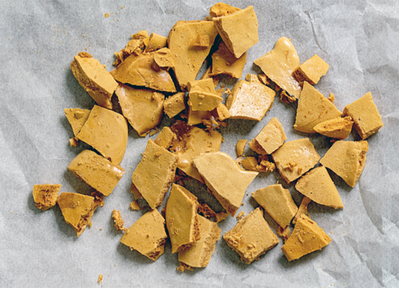 pieces of hokey pokey cinder toffee arranged on a sheet of greaseproof paper