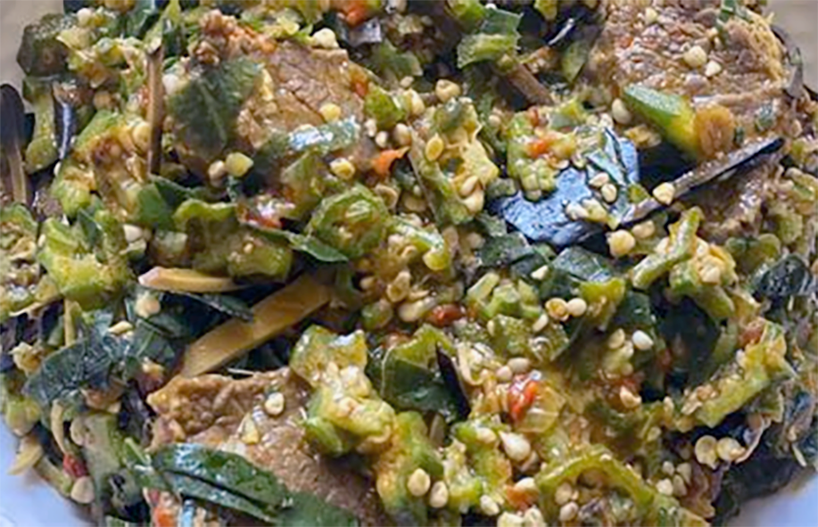 stew of oil beans, okra, pumpkin leaf, ground snail and fish served on a plate