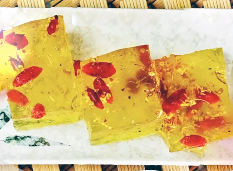 three blocks of osmanthus and goji berry jelly arranged on an oblong plate