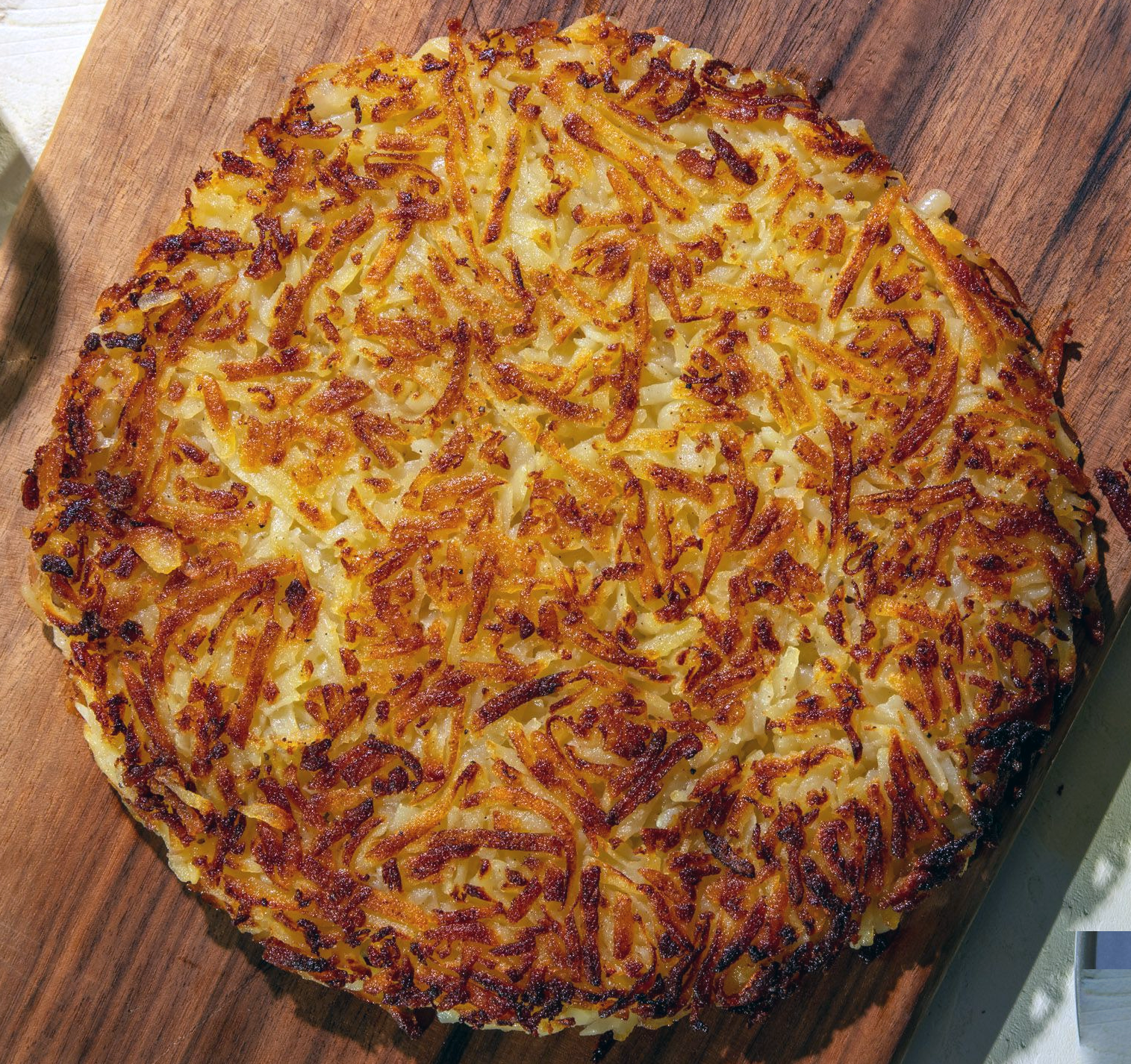 oven-baked rosti cake served on a wooden chopping board