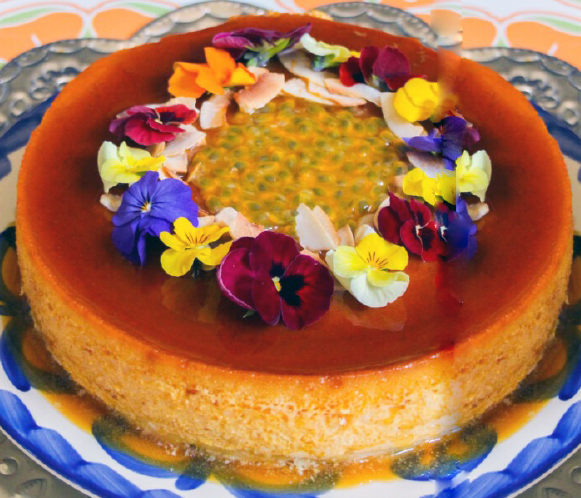 Mexican passionfruit and coconut flan served on a plate with a garnish of edible flowers and passionfruit in the centre