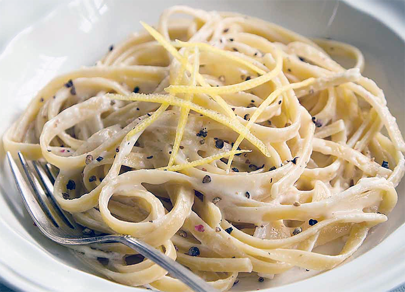 pasta al limone in a white bowl with a fork