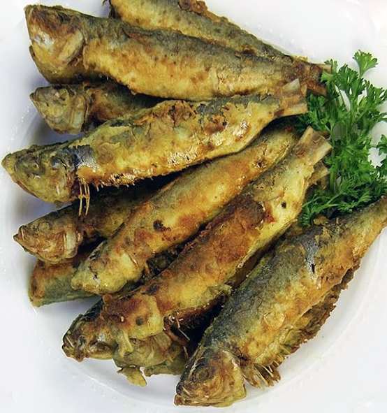 12 fried herring splayed out as a fan on a white plate