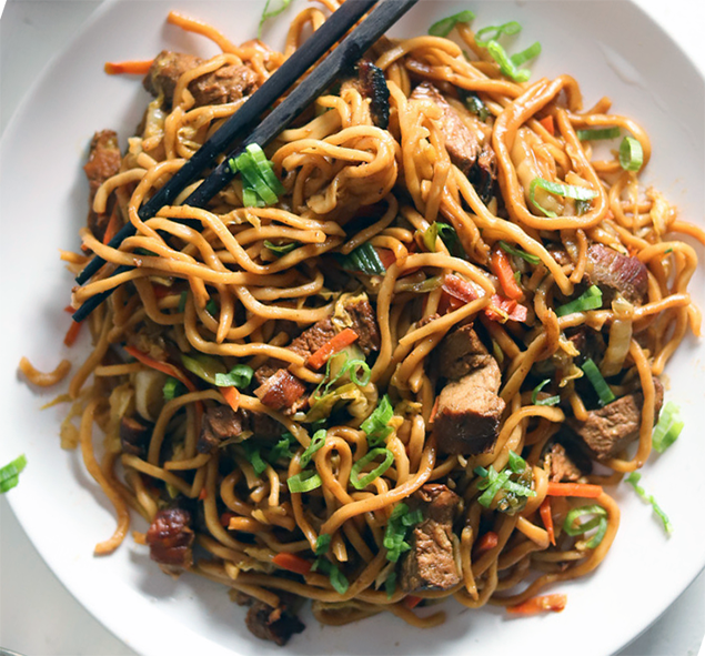 pork noodle lo mein on a white plate with chopsticks