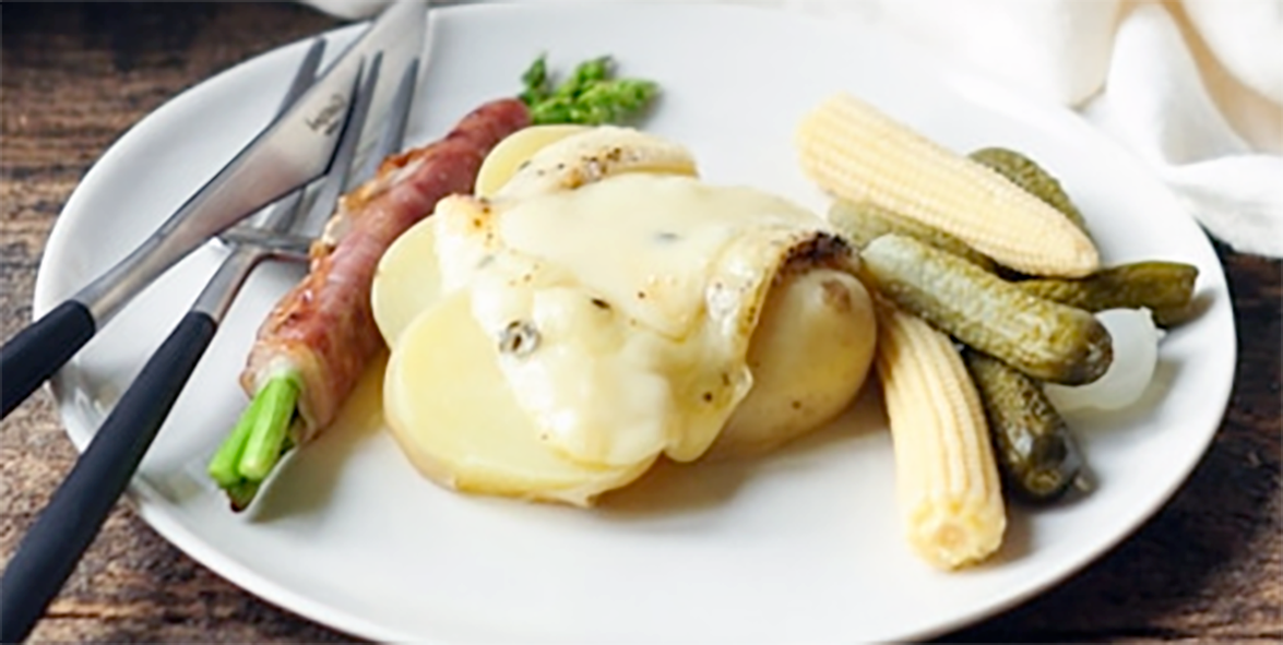 melted raclette cheese served on boiled new potatoes and accompanied by pickled vegetables