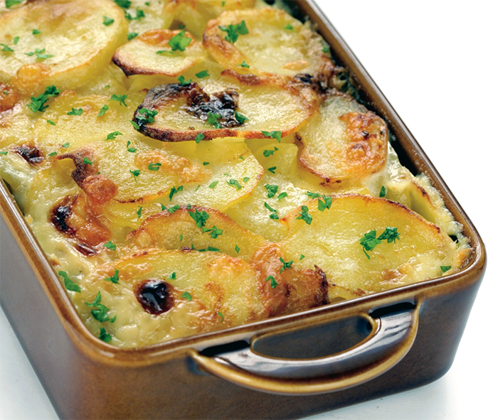 potatoes layered with sliced eggs, cooked sausages and sour cream cooked in a roasting tin