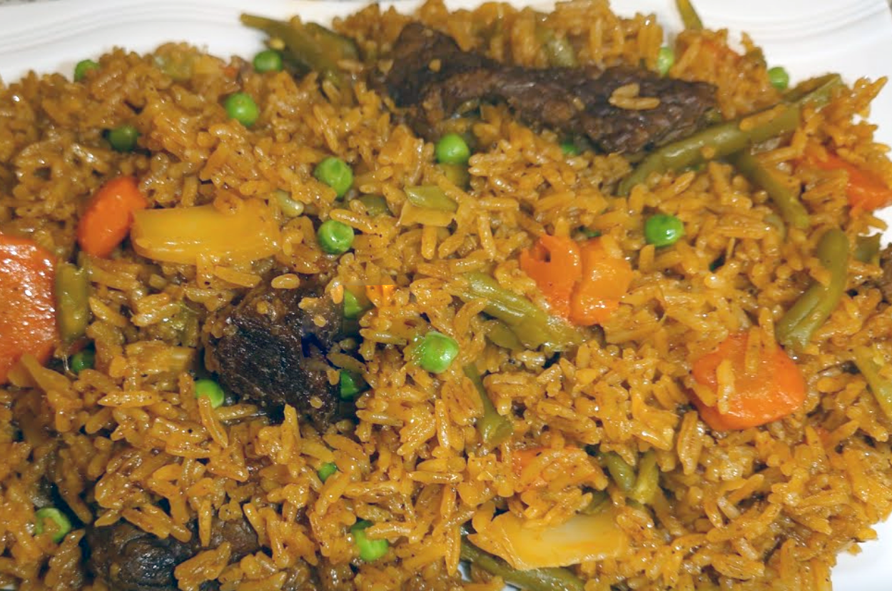 Ivorian rice cooked with beef, vegetables and chillies in a tomato base served on a plate