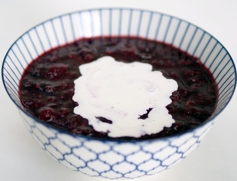 Danish red berry pudding served in a bowl with a garnish of double cream