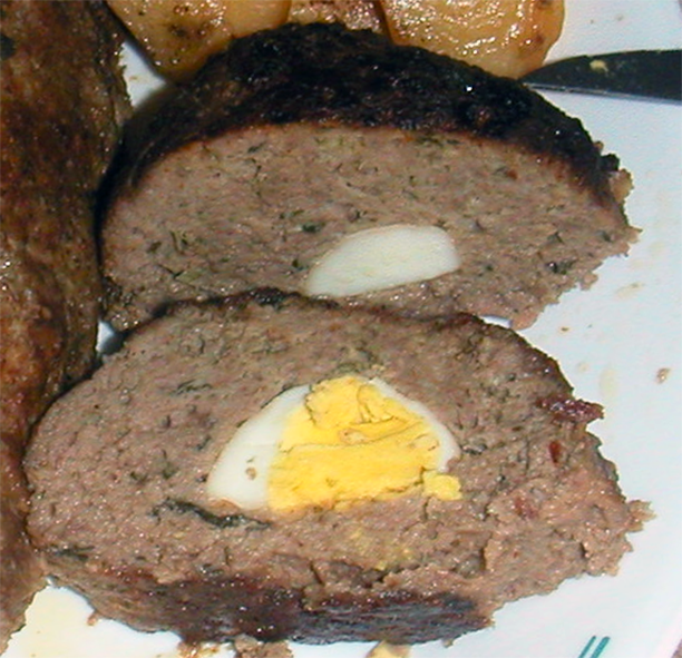 two slices of rolo, cypriot meatloaf with hard boiled egg centre on a plate
