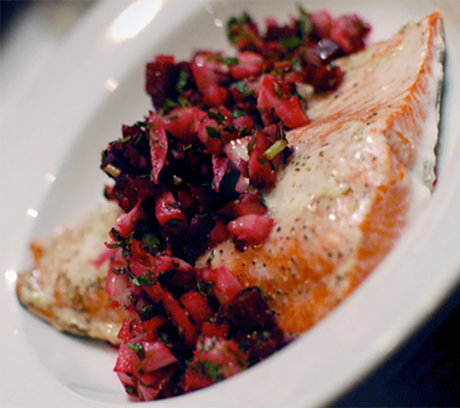 fillet of salmon in a white dish topped with beetroot relish