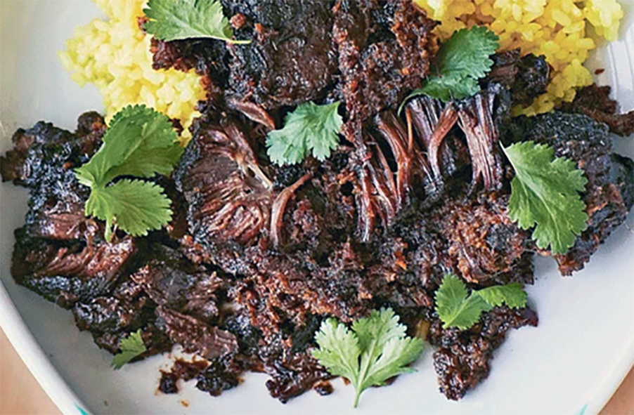 Plate of slow-cooked ox cheek rendang served with short-grain turmeric rice