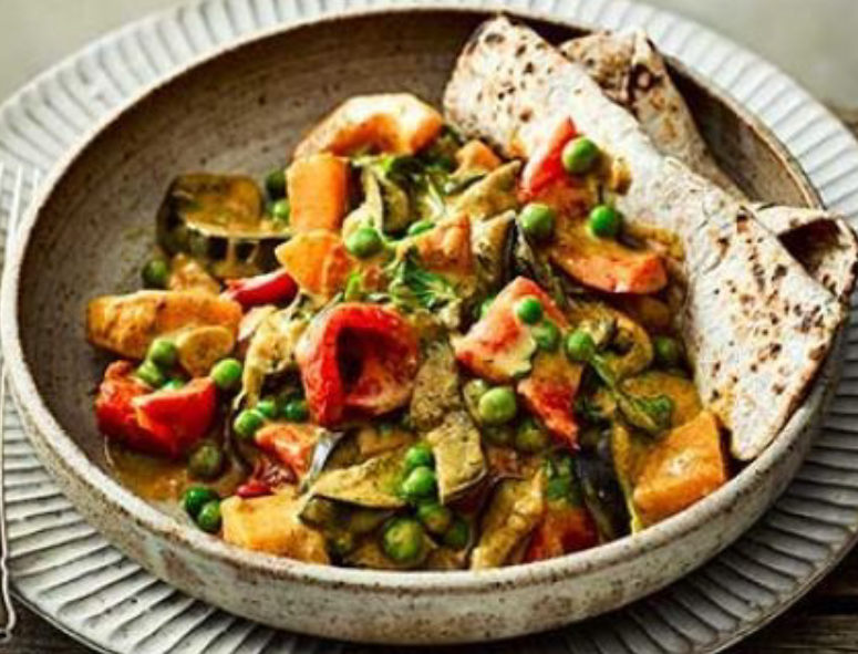 slow cooker vegetable curry served in a bowl with two folded wholemeal flatbreads</al>