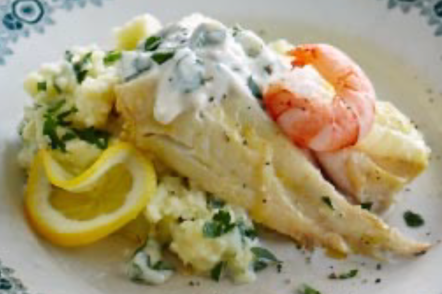 smoked haddock served with a potato and parsnip mash topped with parsley mayonnaise and a king prawn