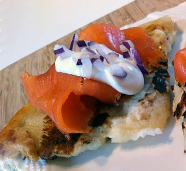 slice of smoked salmon served on a horseradish potato farl garnished with sour cream