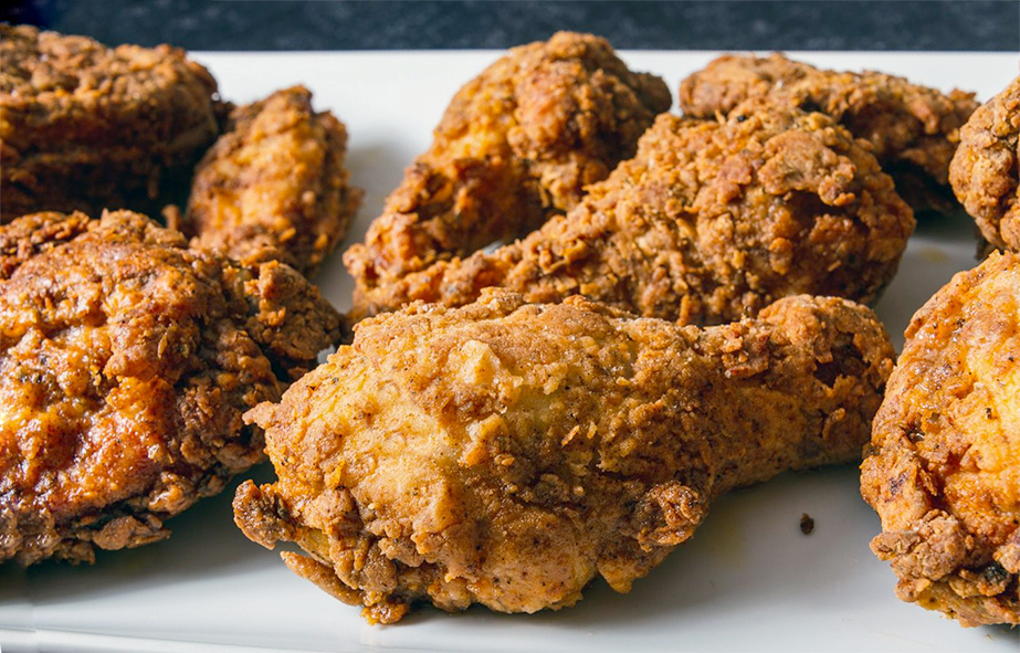 southern fried chicken drumsticks arranged on a white oblong plate