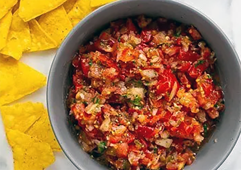 spicy tomato salsa in a bowl with tortilla chips on the side