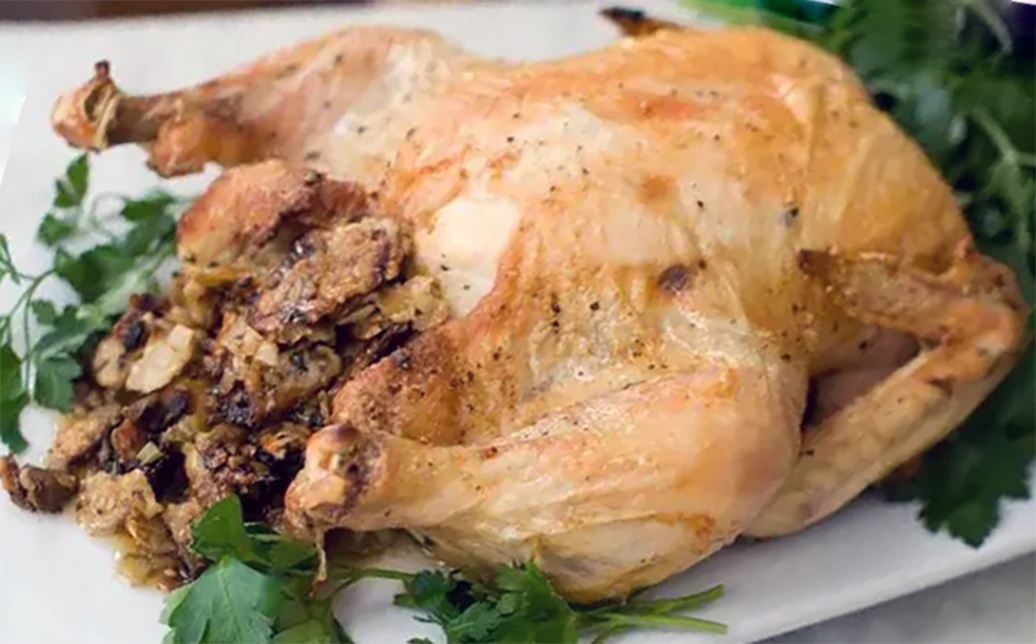stuffed roast chicken on a plate garnished with coriander