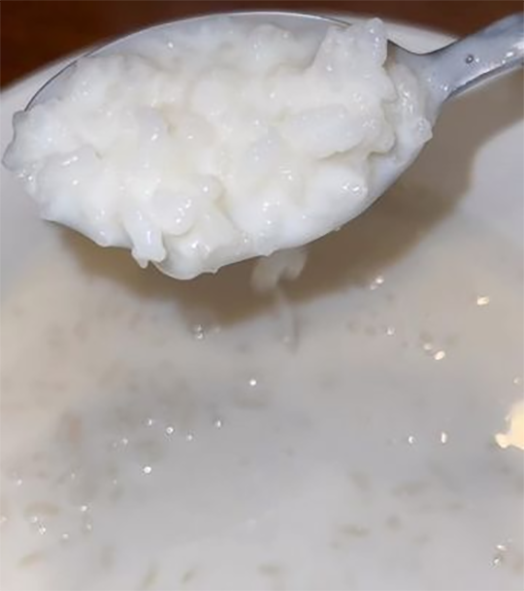 Sua alaisa, Samoan rice pudding in a bowl with the rice grains lifted on a spoon