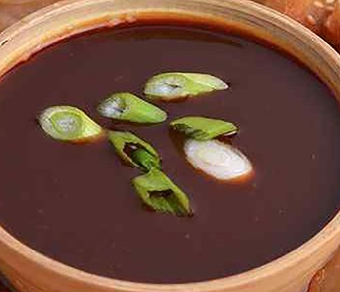 sweet ginger sauce in a bowl garnished with sliced spring onions