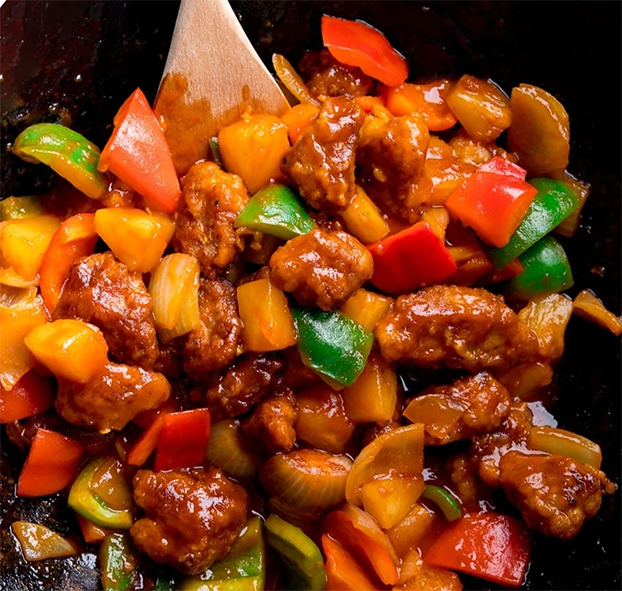 sweet and sour pork frying in a wok