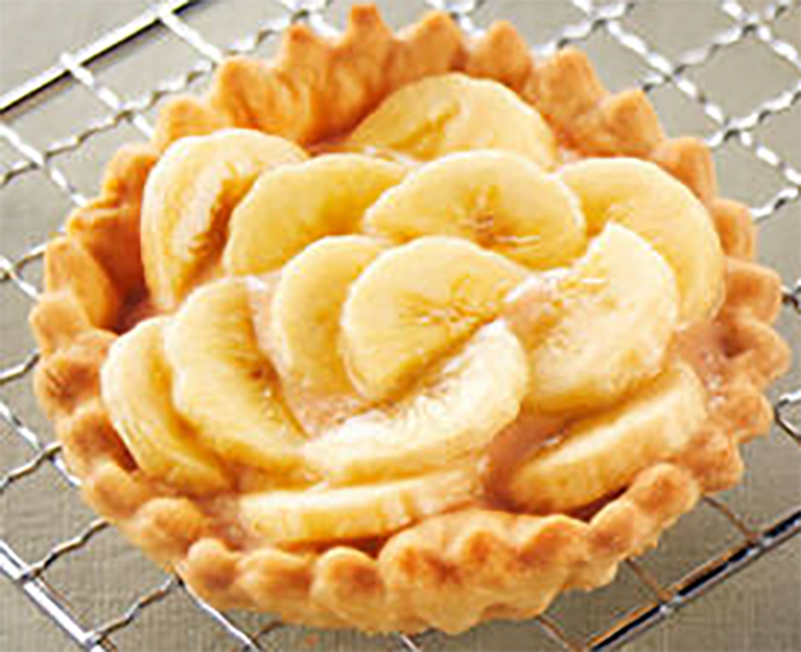 individual banana filled tart on a wire rack