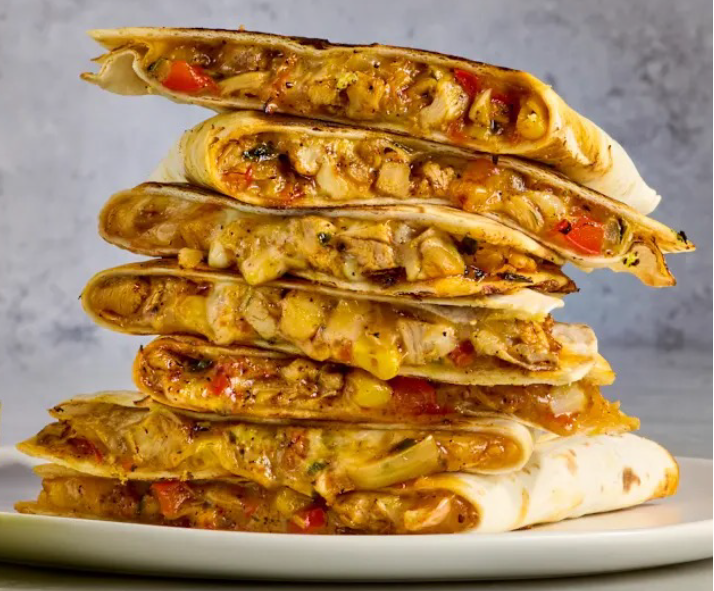 stack of tex-mex quesadillas on a plate, revealing the chicken-based filling