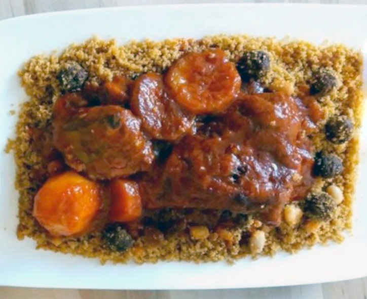 chicken and carrots in a spicy tomato sauce served on a bed of couscous