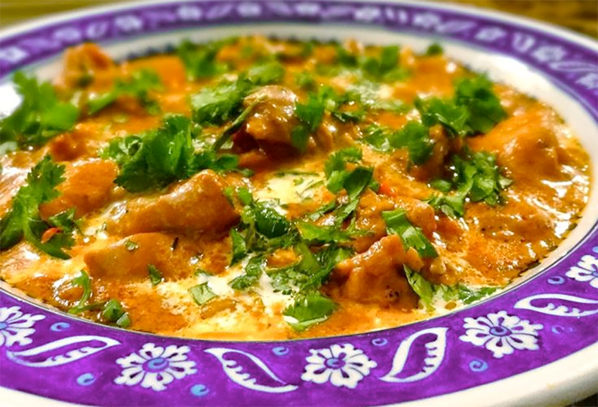 stew of chicken and vegetables in a tomato and peanut base