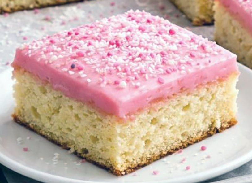 square of pink-iced Tottenham cake on a white plate
