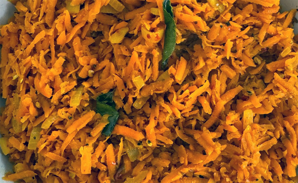 carrot sambal served in a bowl with a curry leaf garnish