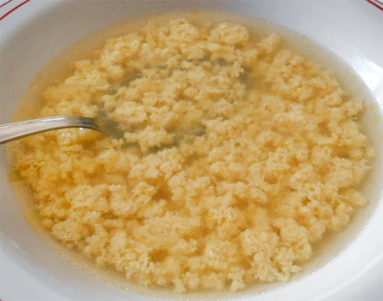 soup of an eggs, parmesan cheese and breadcrumb blend in a chicken consomme base